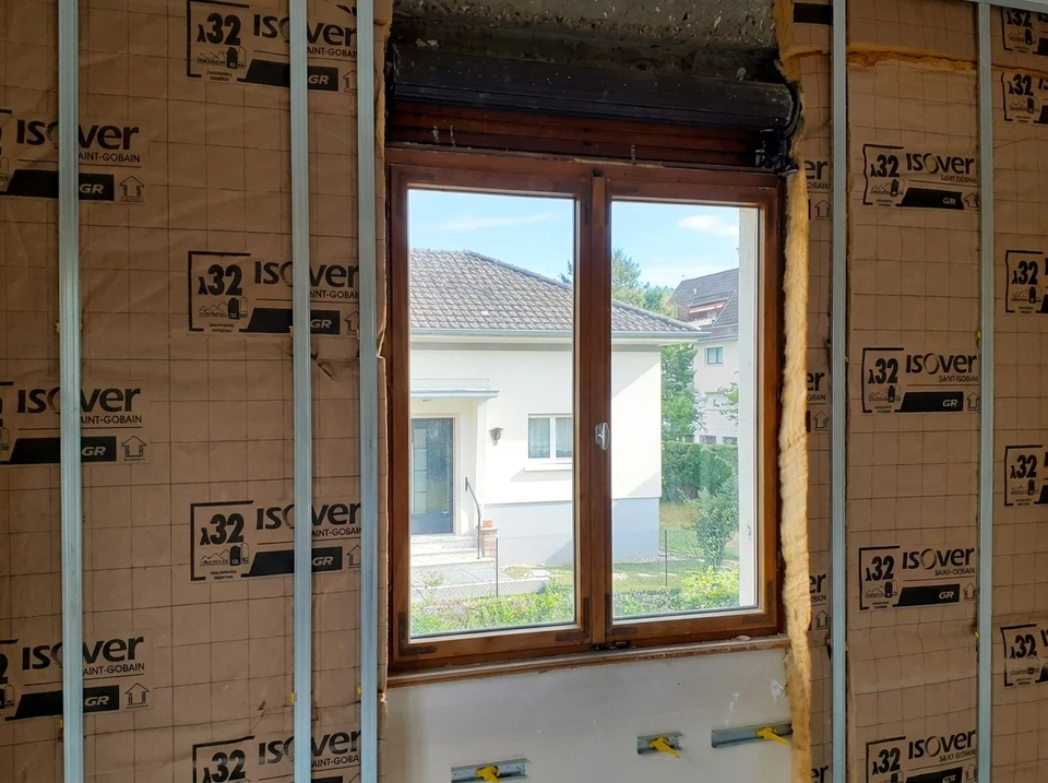 Combles en rénovation avec isolation thermique jaune entre chevrons apparents