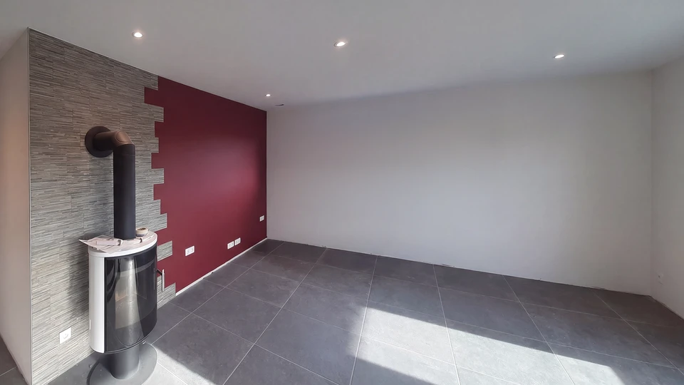 Femme peignant un mur intérieur avec un rouleau à peinture blanche