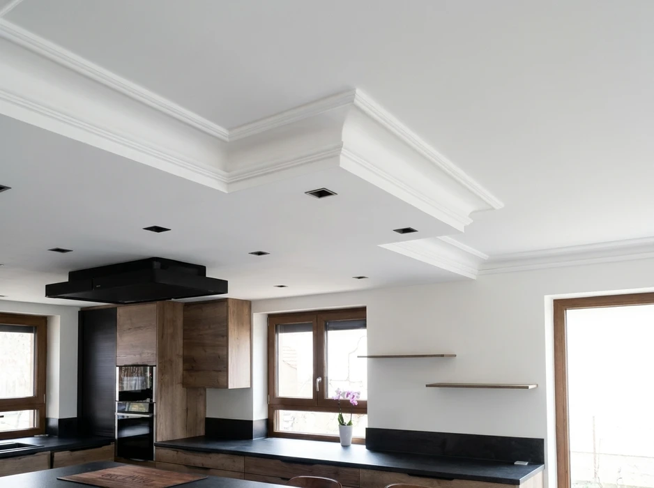 Combles en cours d'aménagement, murs en plâtre blanc lissé, plafond en pente formant un angle triangulaire