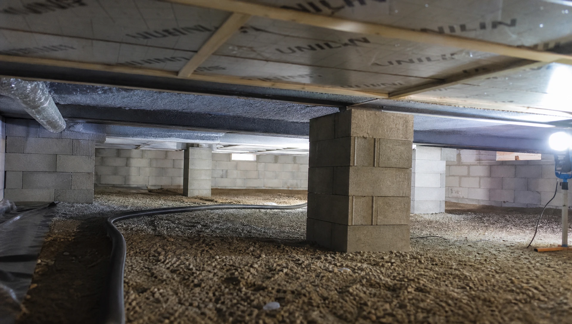 Intérieur d'atelier avec rouleaux d'isolant thermique posés sur plancher OSB