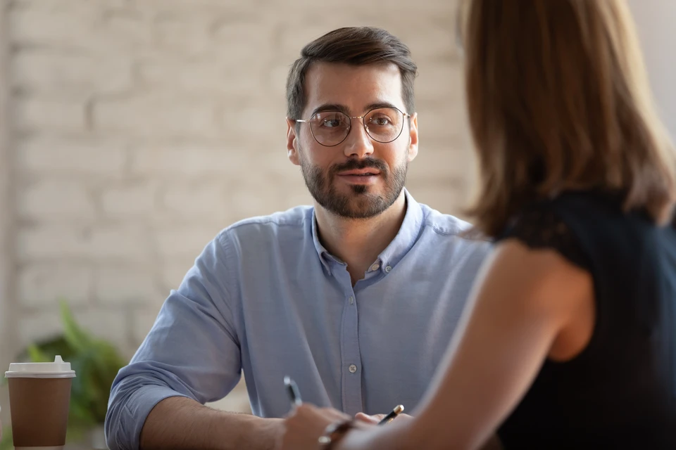 Un artisan ou responsable de chantier expliquant son diagnostic à un couple ou un client dans un intérieur en cours de rénovation, pointant des éléments de la maçonnerie, des murs ou des zones d'isolation. L'ambiance doit montrer une conversation authentique de conseil dans un contexte résidentiel réel, avec des matériaux et structures visibles en arrière-plan, reflétant le professionnalisme et la transparence du diagnostic de rénovation.